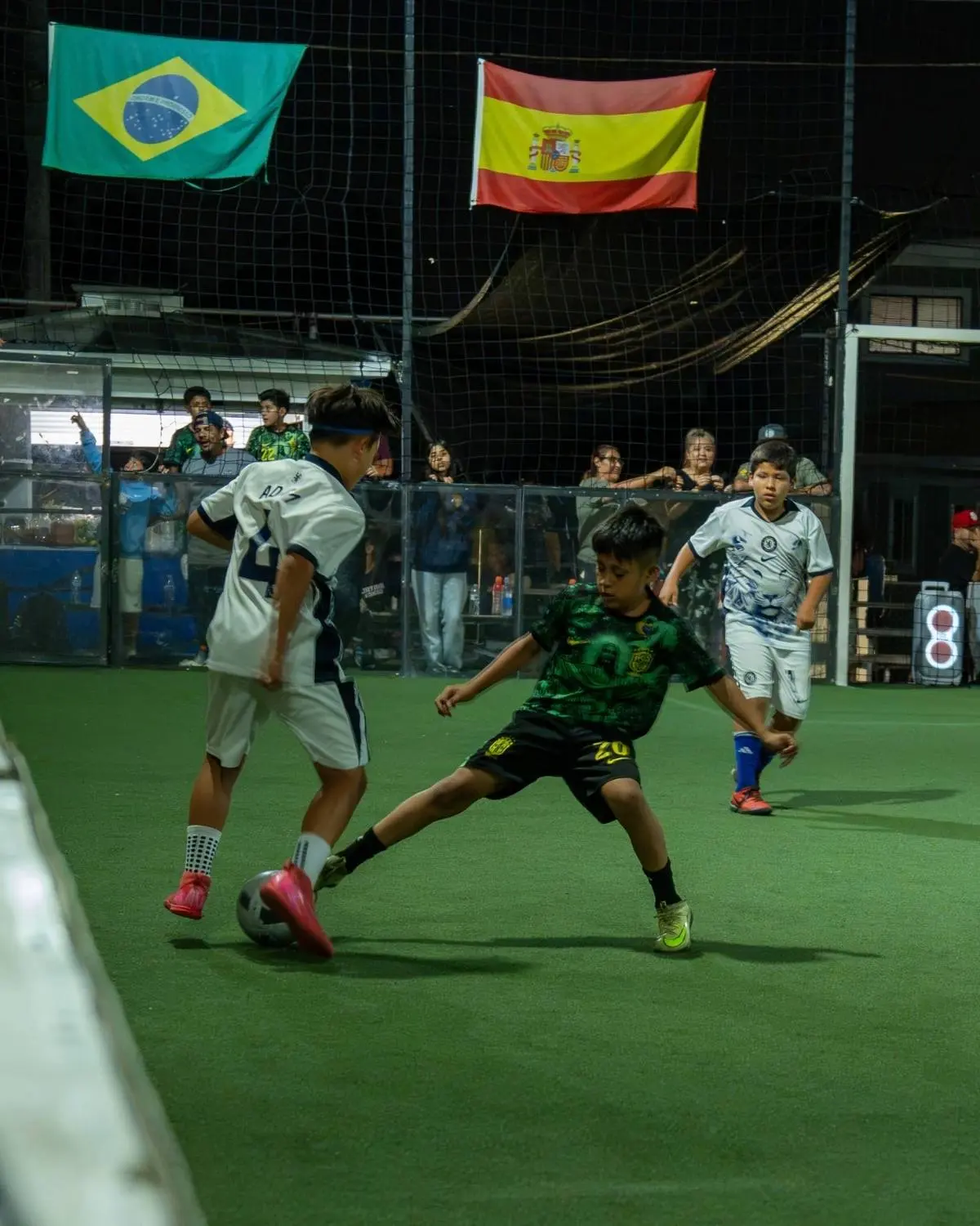 Youth player slides in for a tackle during a night game at EVO St in San Diego